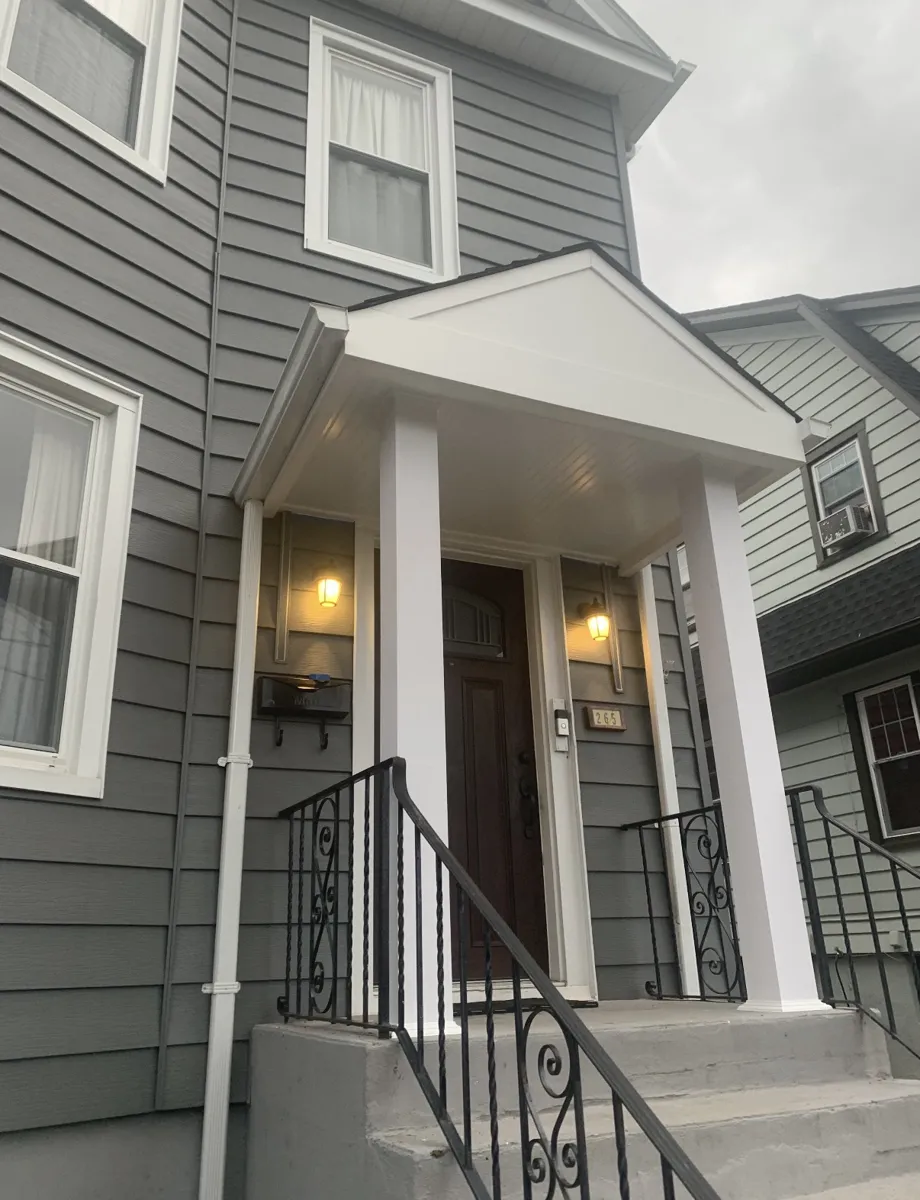 Same front entry with the rebuilt white covered canopy on square columns