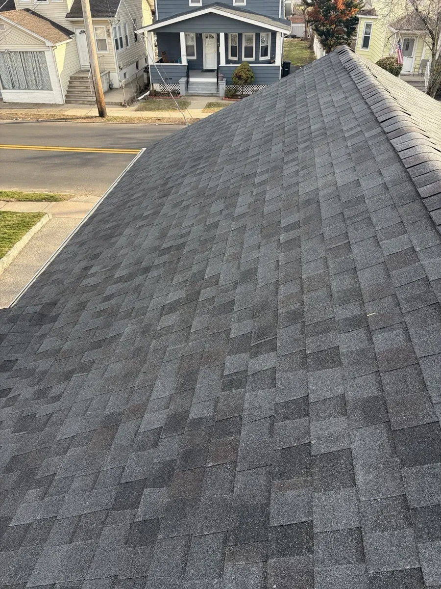 Finished charcoal architectural shingle roof with ridge cap in place